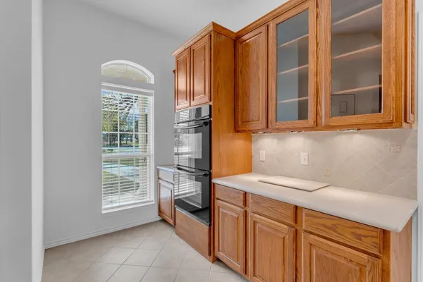 a kitchen with stainless steel appliances granite countertop a refrigerator a sink dishwasher and wooden cabinets with wooden floor