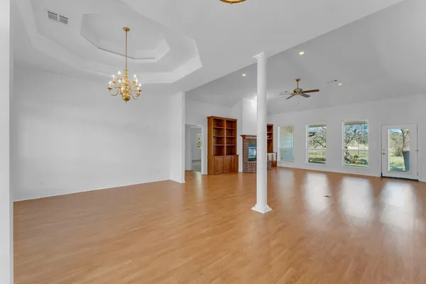 an empty room with wooden floor and window