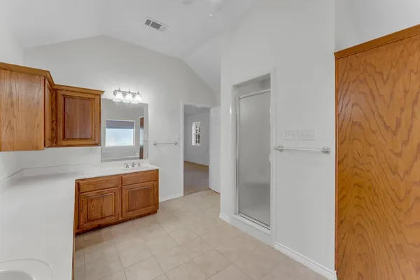 a bathroom with a double vanity sink a mirror and a shower