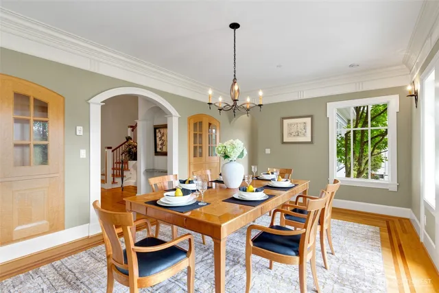 a dining room with furniture a chandelier and wooden floor