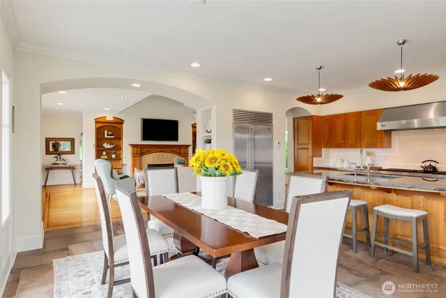 a dining room filled chandelier and wooden floor