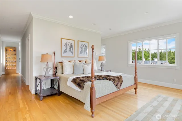 a spacious bedroom with a bed and wooden floor