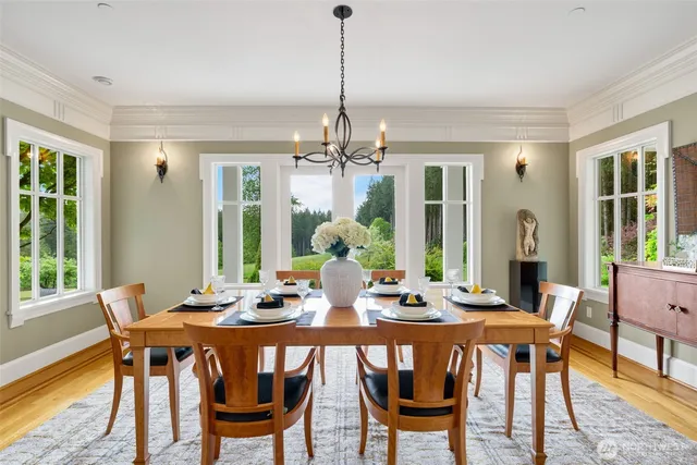 a dining room with furniture a chandelier and wooden floor