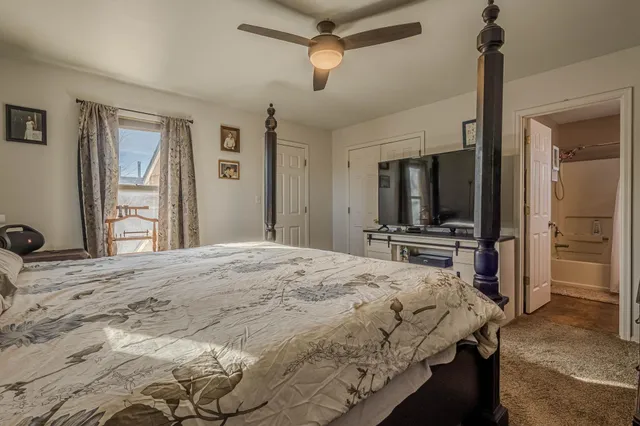 a bedroom with a bed and a large mirror on the dresser