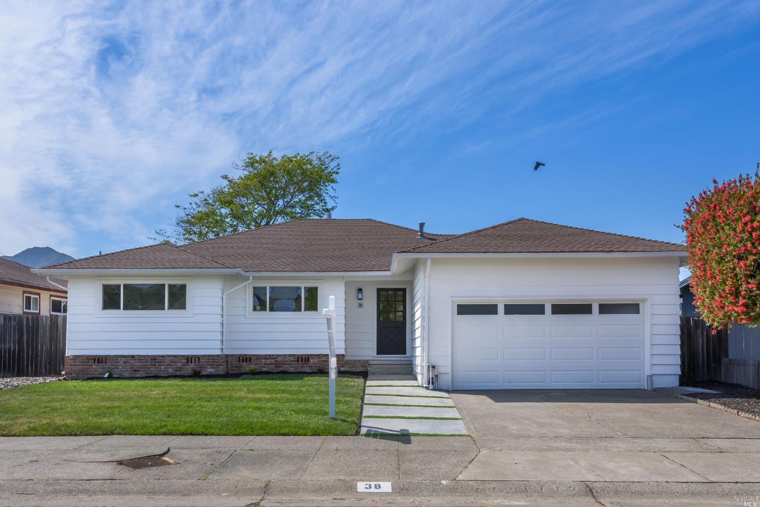 a front view of a house with a garden and yard