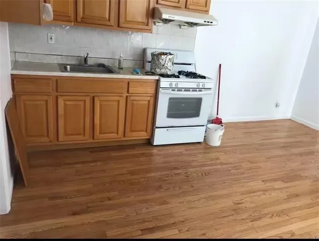 a kitchen with stainless steel appliances granite countertop a stove a sink and a microwave