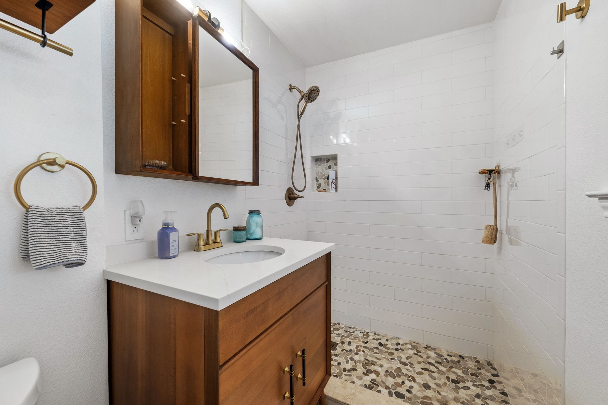 401 Ranchview Drive Johnson City, TX 78636 - Photo 23 of 40 bathroom featuring beautiful wood vanity and a tile shower w river rock shower floor