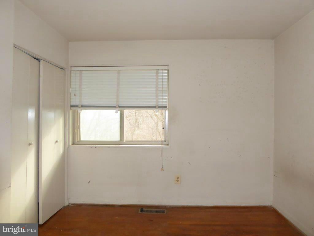 8706 Manchester Road, Unit 6 Silver Spring, MD 20901 - Photo 11 of 12 an empty room with wooden floor and windows