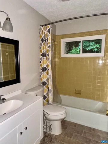 a bathroom with a sink a toilet and shower curtain