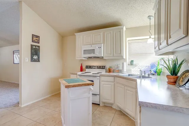 a kitchen with a sink a stove and cabinets
