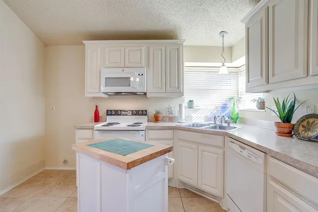 a kitchen with a sink a stove and cabinets