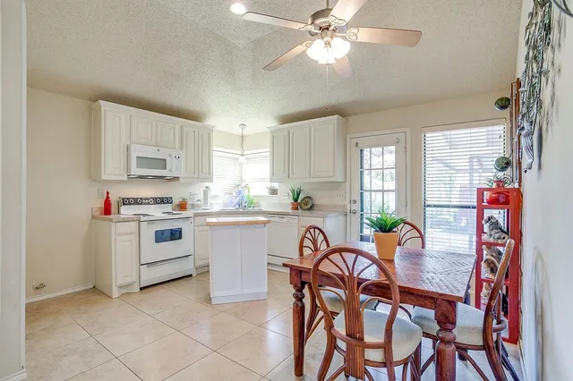 a kitchen with a dining table chairs and cabinets