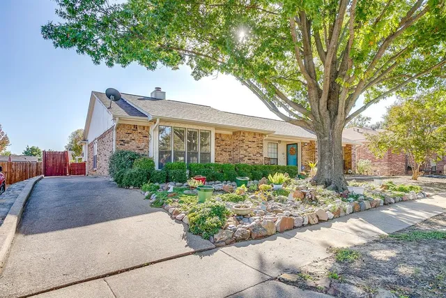 a front view of a house with a yard and a garden