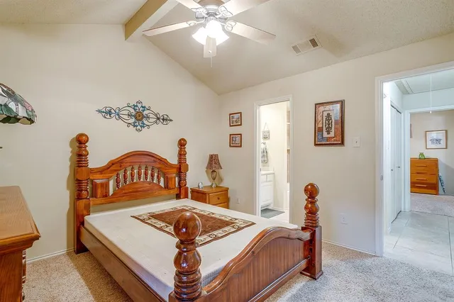 a bedroom with a bed a chandelier and a dresser