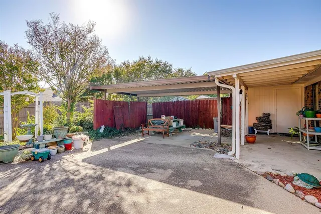 a view of a patio with table and chairs potted plants and wooden fence