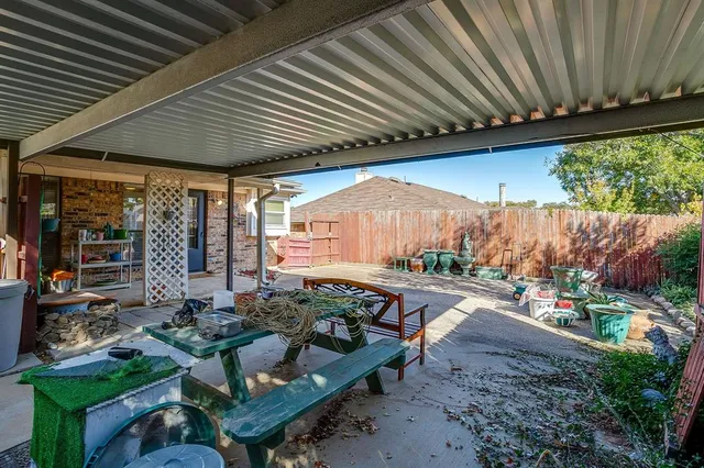 a backyard of a house with plants and large trees