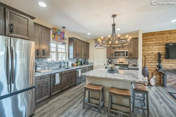 a kitchen with kitchen island granite countertop a sink stove and refrigerator