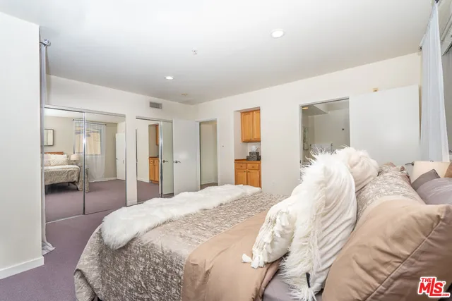 a bedroom with a large bed and chandelier