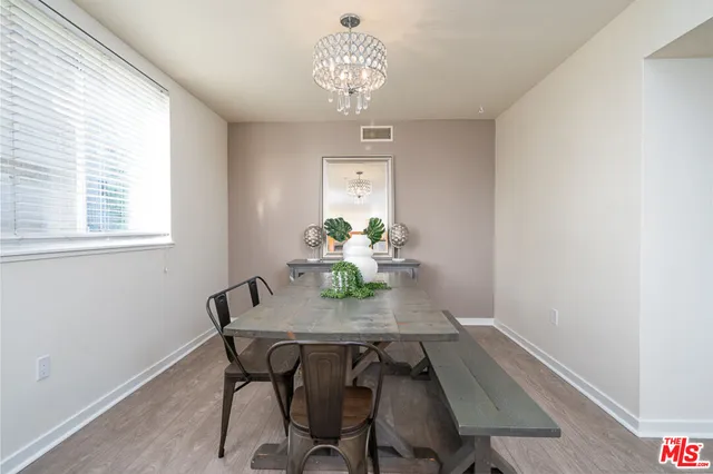 a dining room with furniture a chandelier and wooden floor
