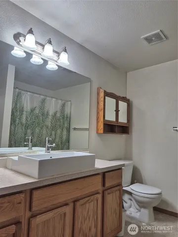 a bathroom with a granite countertop sink a large mirror and a shower