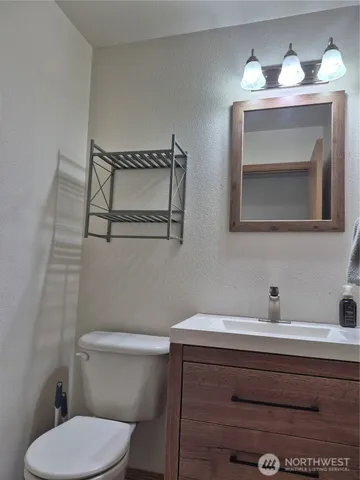 a bathroom with a toilet a sink and mirror
