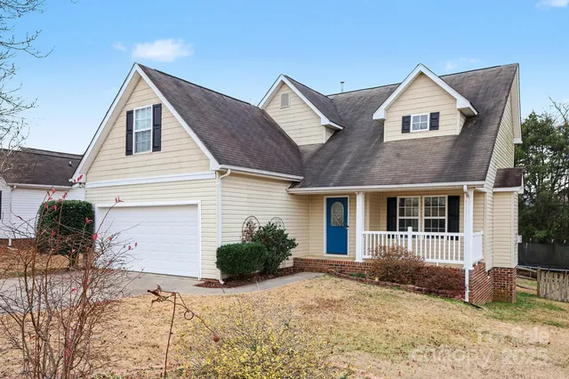 a view of a house with a yard and potted plants