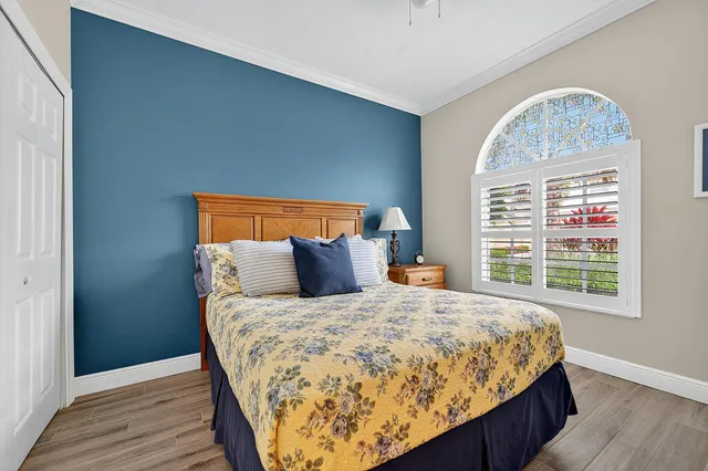 a bedroom with a bed and a wooden floor