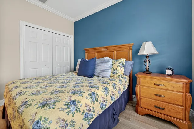 a bedroom with a bed and a lamp on dresser