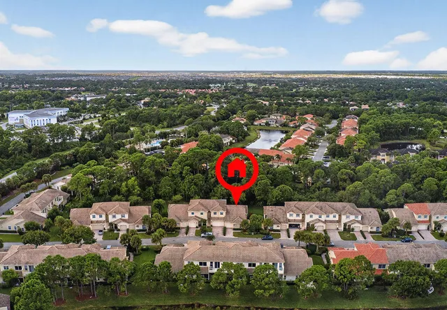 an aerial view of a house with swimming pool and large trees