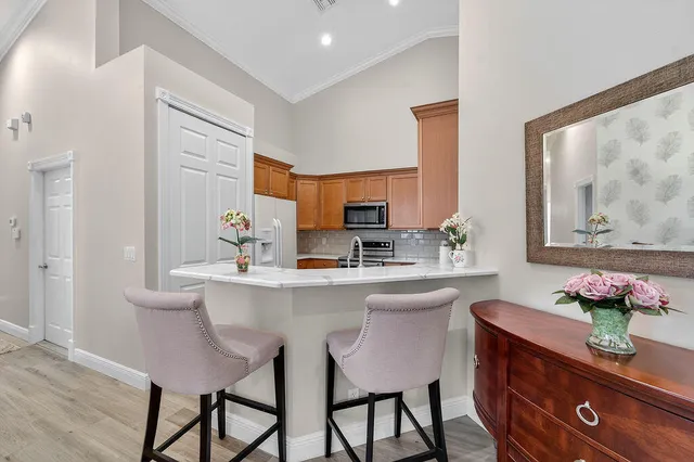 a kitchen with stainless steel appliances a table and chairs in it