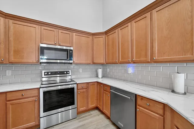 a kitchen with stainless steel appliances granite countertop a sink a stove a microwave and cabinets