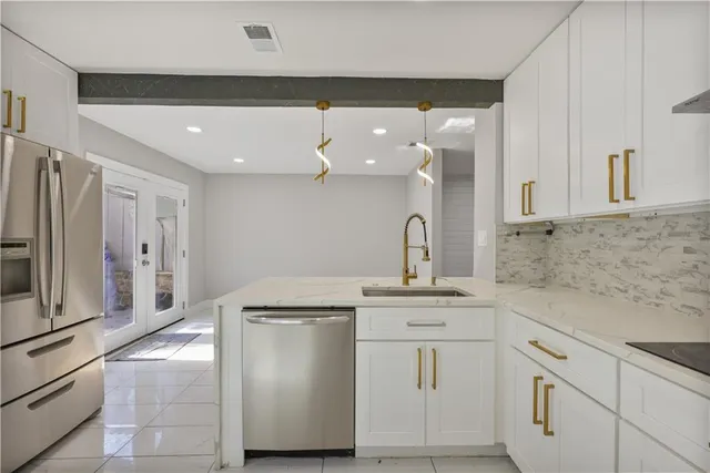 a kitchen with white cabinets and stainless steel appliances