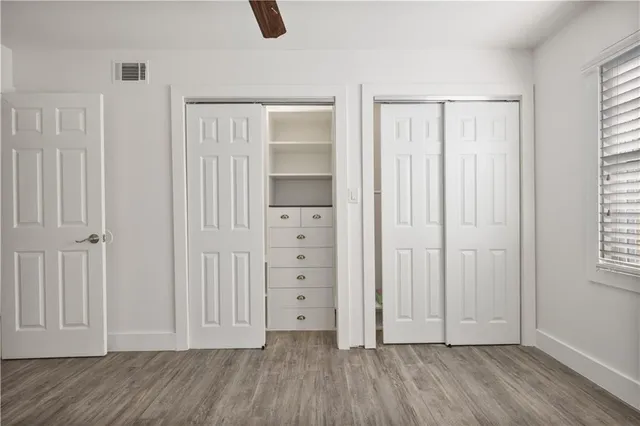 an empty room with windows and closet