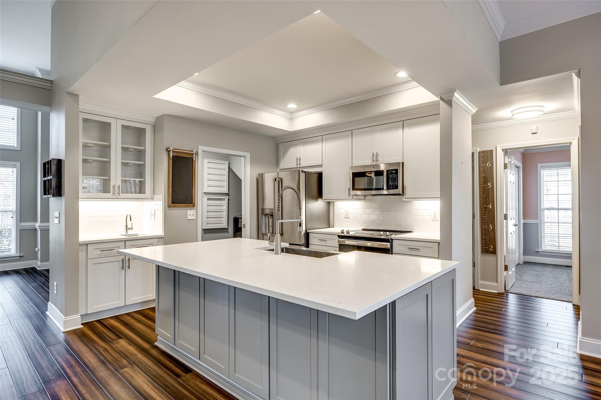 1352 North Dobys Bridge Road Fort Mill, SC 29715 - Photo 8 of 31 a kitchen with stainless steel appliances a stove top oven a sink dishwasher a refrigerator and white cabinets with wooden floor