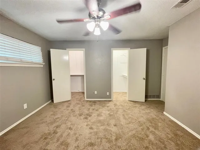 an empty room with fan and entrance