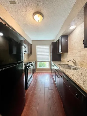 a kitchen with stainless steel appliances granite countertop a stove a sink and a refrigerator