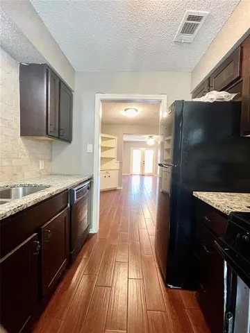 a kitchen with granite countertop stainless steel appliances and wooden cabinets