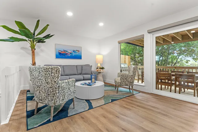 a living room with furniture a large window and a wooden floor