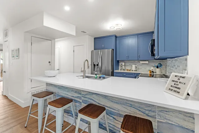 a kitchen with kitchen island a stove a table and chairs in it