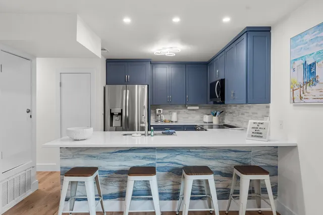 a kitchen with granite countertop a dining table chairs and a stove top oven