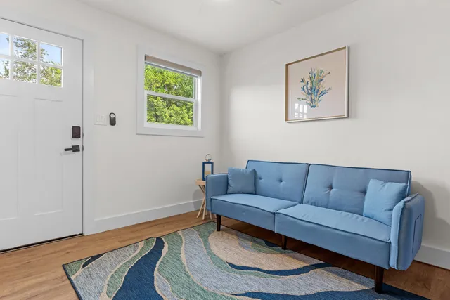a living room with furniture and a wooden floor