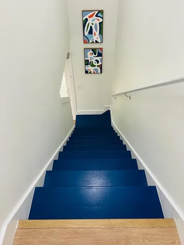 a bedroom with a large bed and wooden floor