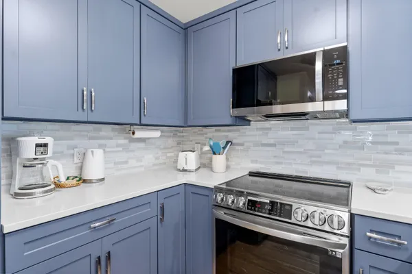 a kitchen with stainless steel appliances a stove a microwave and sink
