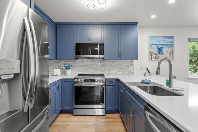 a kitchen with stainless steel appliances granite countertop a sink stove and refrigerator