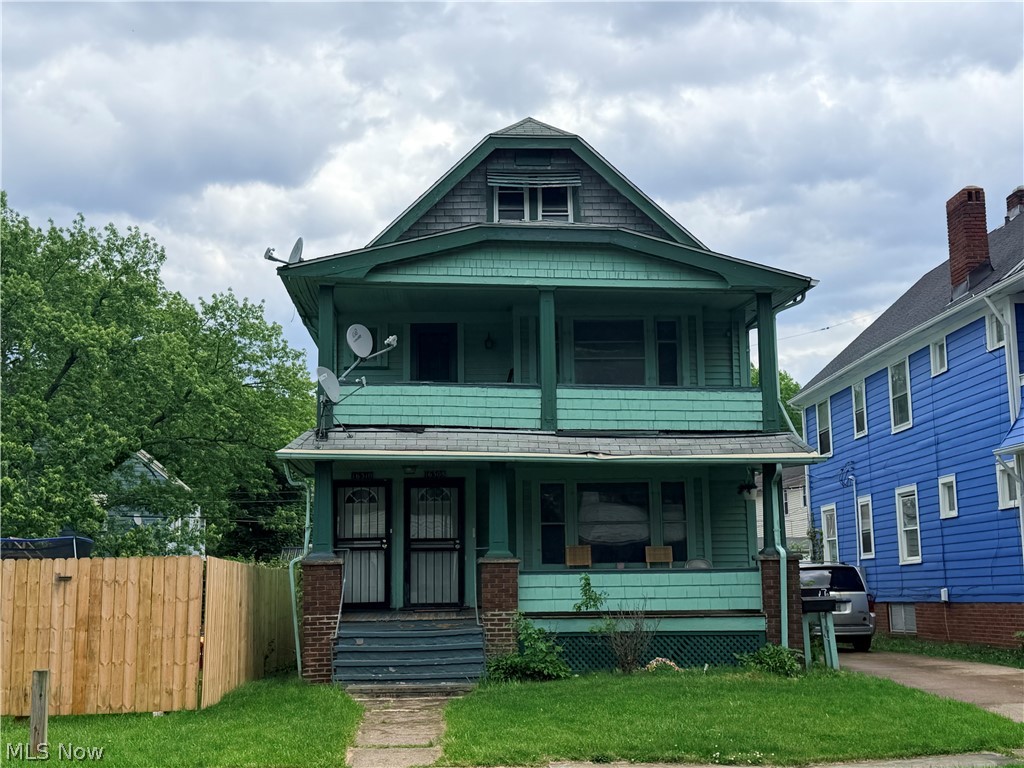 Two-story residence featuring a covered front porch and a prominent attic dormer