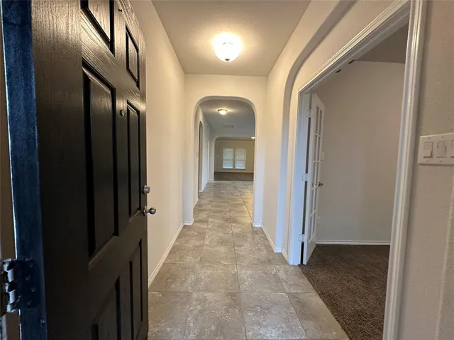 view of a hallway with wooden shelves