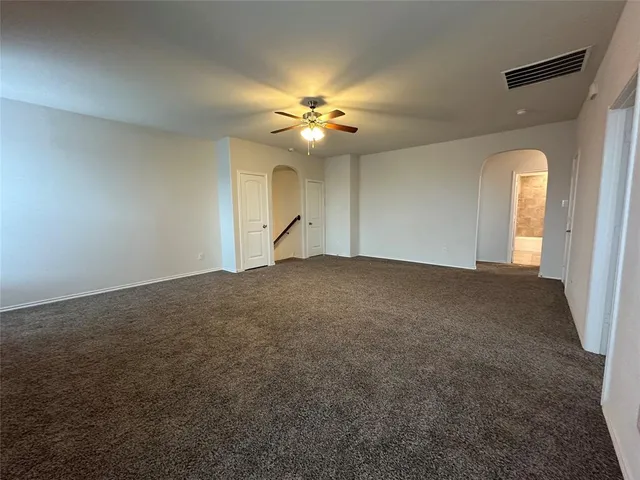 an empty room with closet and a chandelier fan