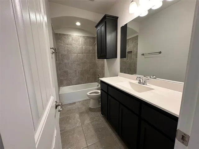 a bathroom with a double vanity sink toilet mirror and bathtub