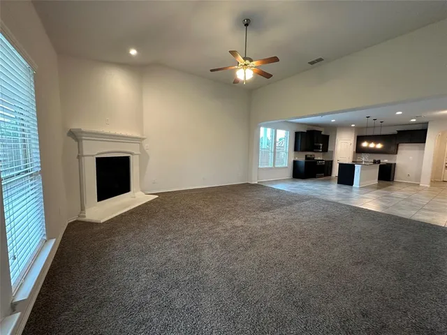 an empty room with a fireplace and chandelier