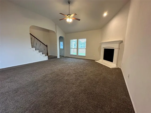 a view of an empty room with a fireplace and a window